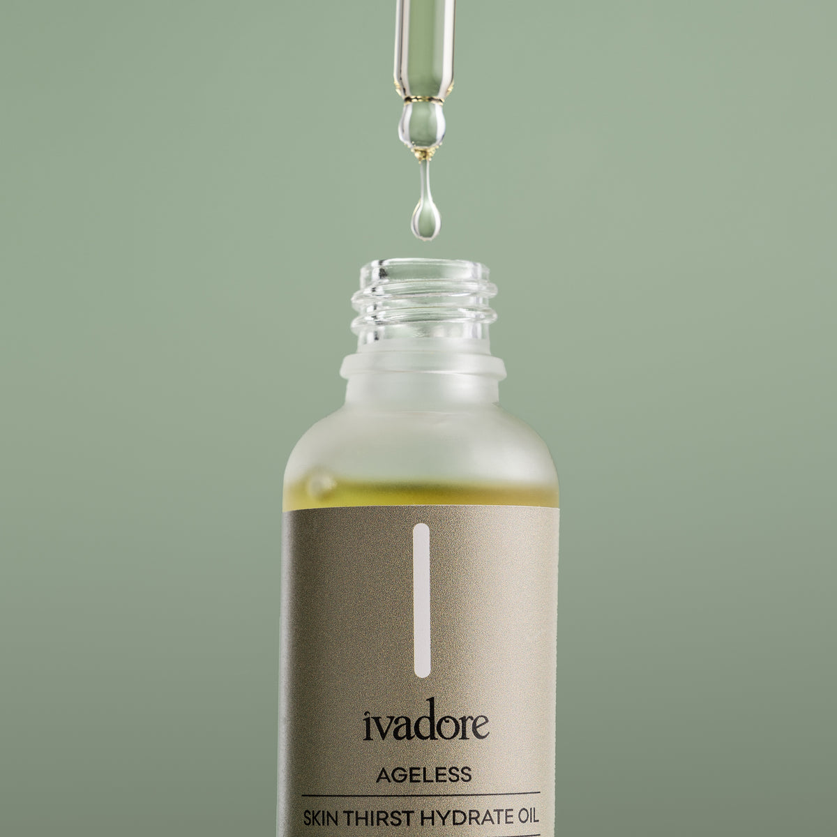 Close up view of Ivadore Ageless face oil with glass pippette dripping oil into bottle