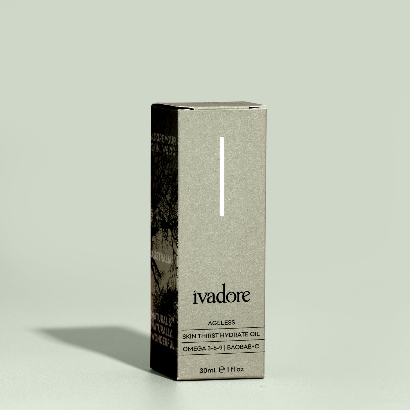 Flatlay view of Ivadore Ageless face oil surrounded by clear oil droplets