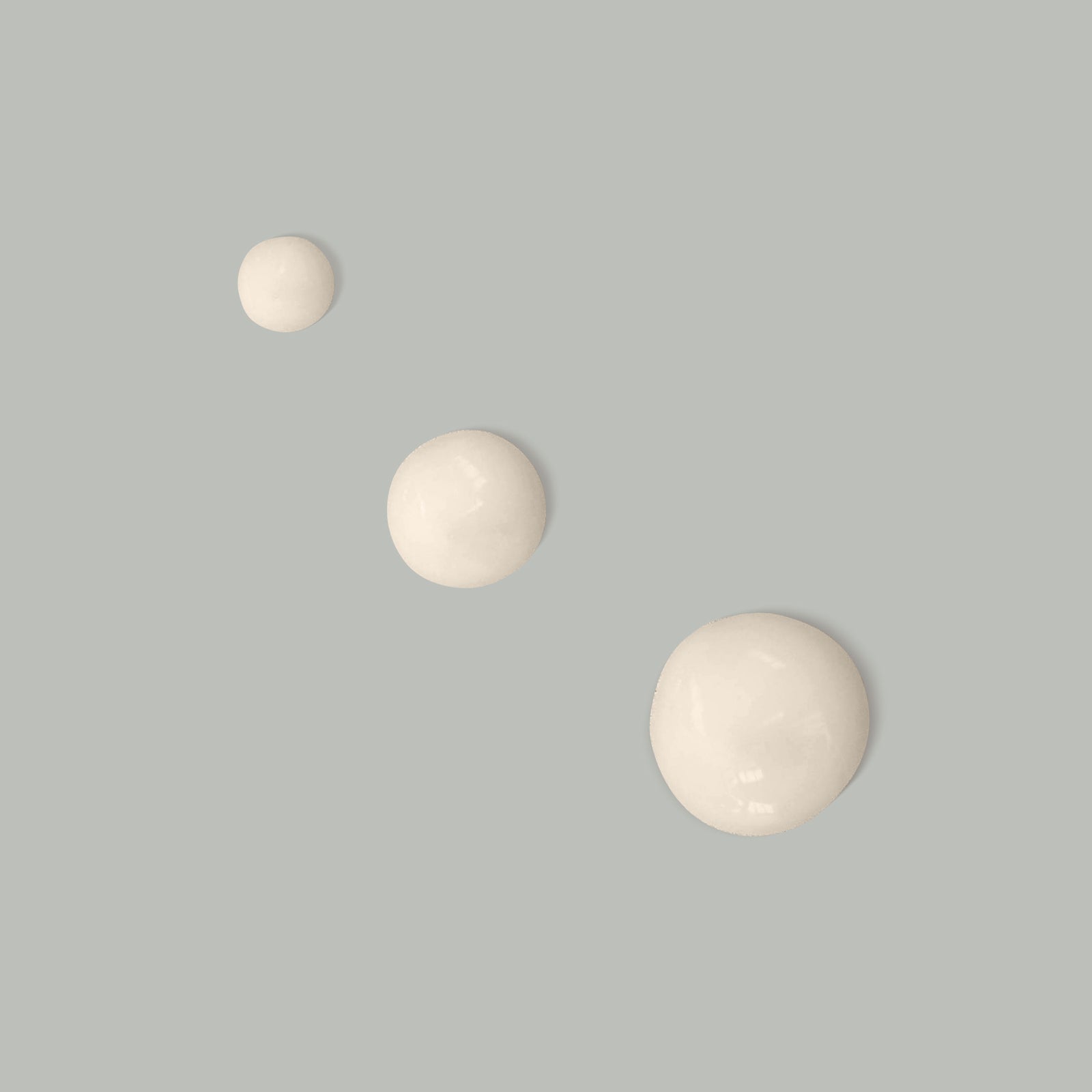 A face tan bottle and an exfoliating polish bottle standing side by side on peach coloured background.