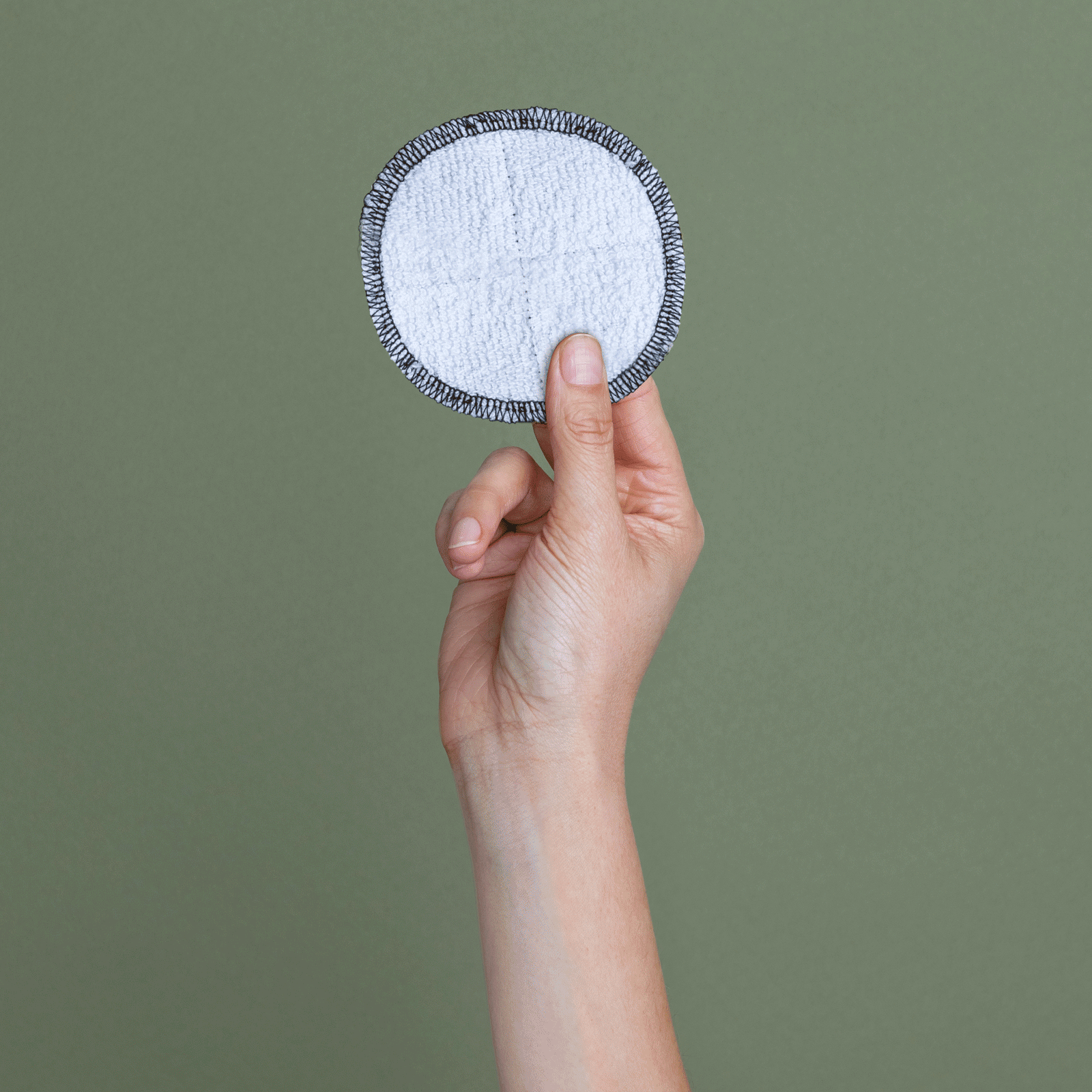 Female hand holding single washable facey wipe