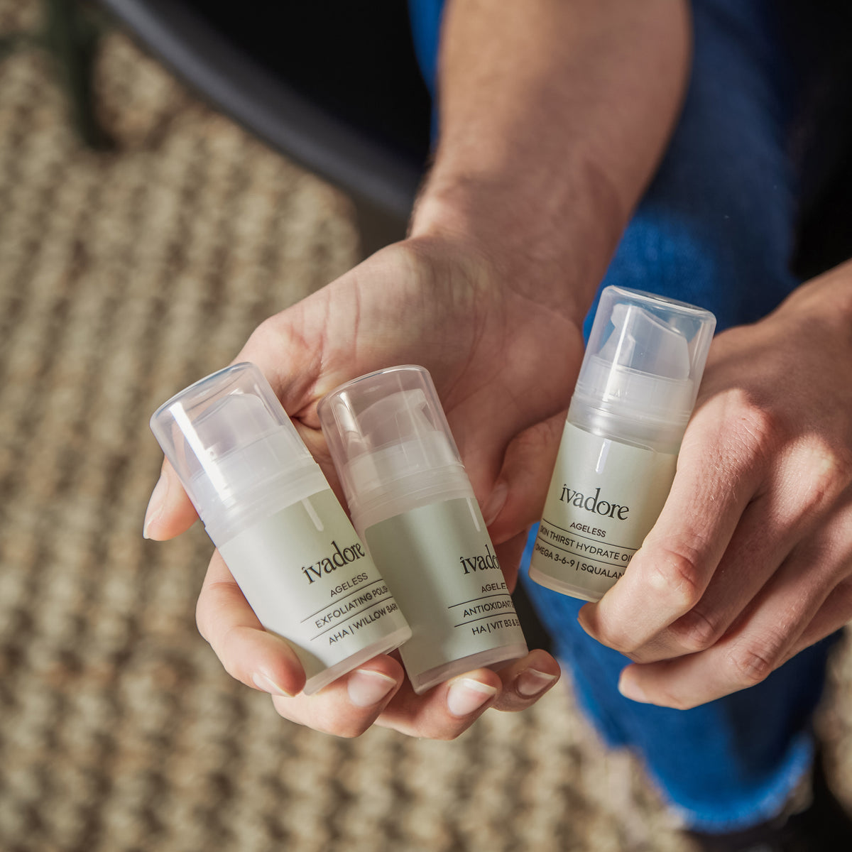 Female hands holding three mini bottles from the Ageless Skin System set 